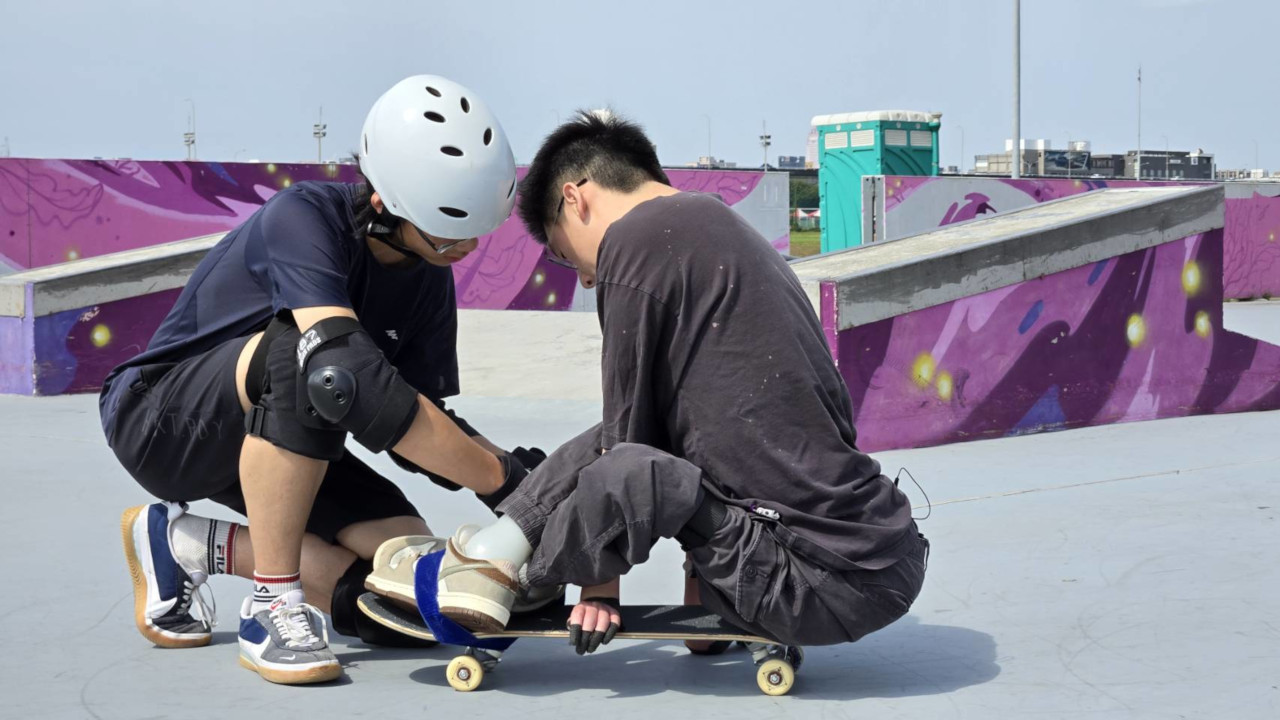 文凱的好友嘉恩調整把文凱固定在滑板上束帶