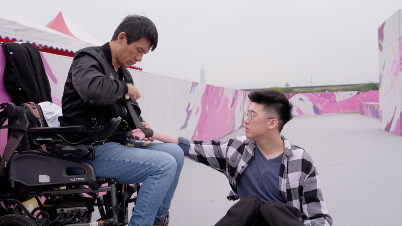 滑板時，文凱爸爸幫他纏彈性繃帶，避免手指手掌破皮